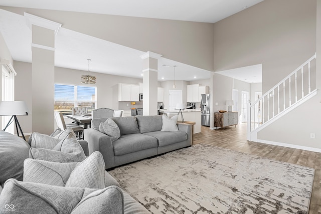 living room with wood-type flooring and high vaulted ceiling