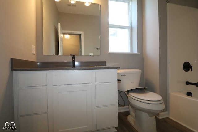 full bathroom with shower / tub combination, vanity, wood-type flooring, and toilet