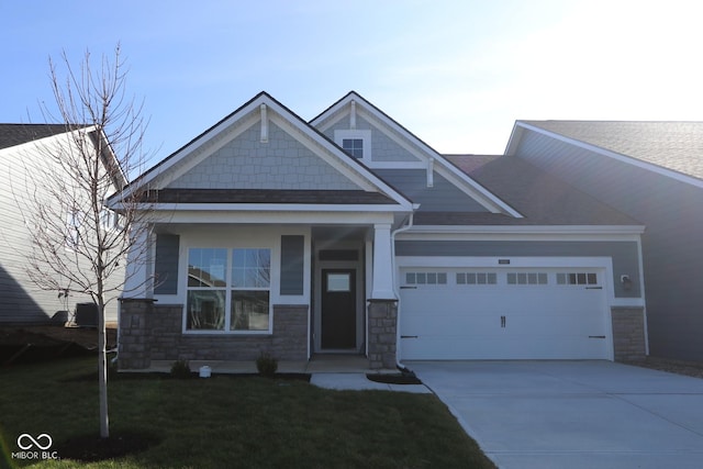 craftsman inspired home with a garage and a front lawn