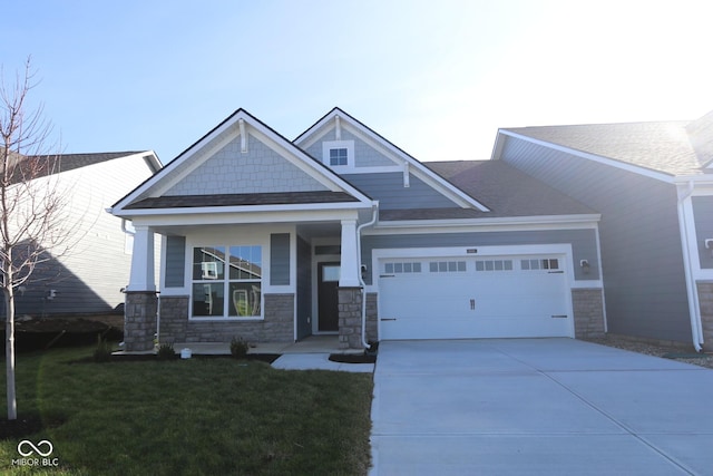 craftsman house with a front lawn and a garage