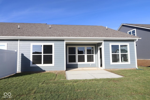 rear view of property featuring a patio and a lawn