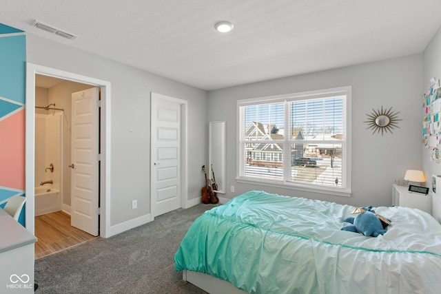 bedroom featuring ensuite bath and carpet