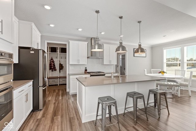 kitchen featuring sink, hanging light fixtures, white cabinets, and appliances with stainless steel finishes