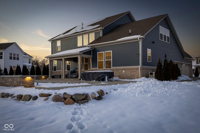 snow covered rear of property featuring a porch