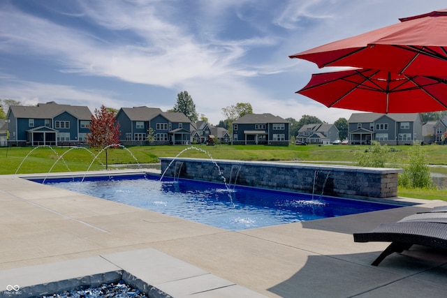 view of swimming pool featuring pool water feature and a lawn