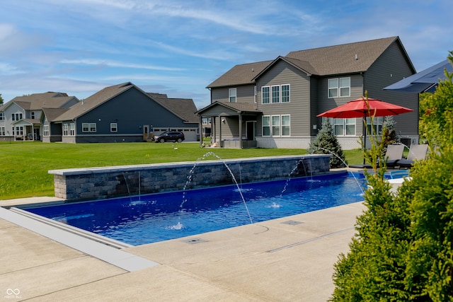 view of swimming pool with pool water feature and a lawn