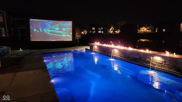 view of swimming pool featuring pool water feature and a fire pit