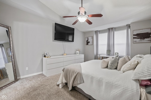 bedroom with ceiling fan, light colored carpet, and vaulted ceiling