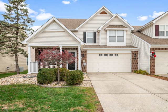 view of front of house featuring a garage, covered porch, a front lawn, and central AC unit