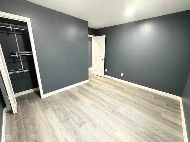 unfurnished bedroom featuring light hardwood / wood-style floors and a closet