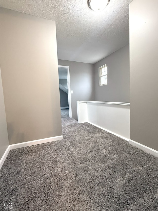 empty room with a textured ceiling and carpet