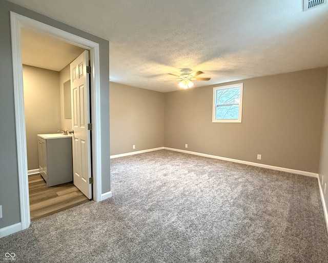 carpeted empty room featuring sink, a textured ceiling, and ceiling fan