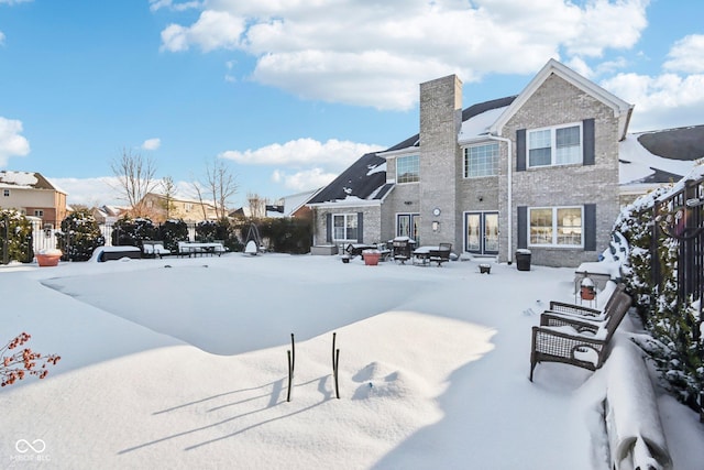 view of snow covered rear of property