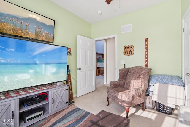 living area with light carpet and ceiling fan