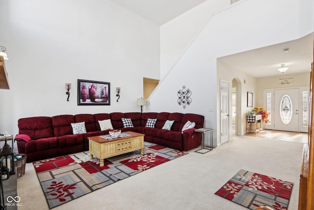 carpeted living room with a towering ceiling