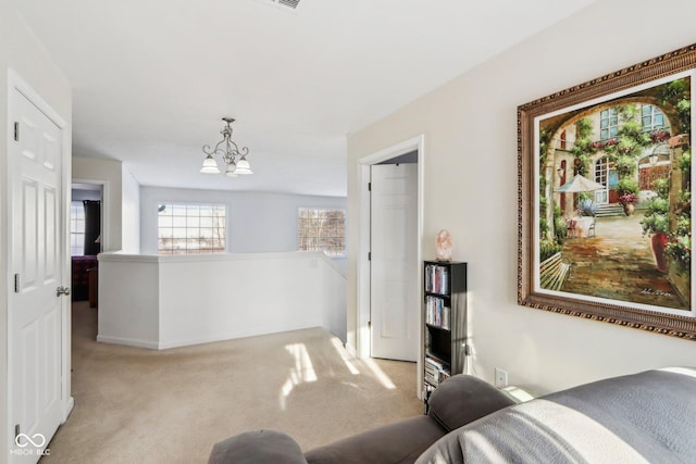 carpeted living room with a chandelier