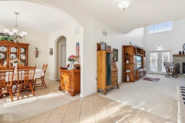 interior space featuring a chandelier, light carpet, and french doors