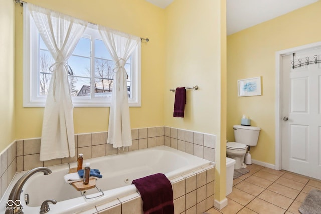 bathroom with tile patterned flooring, a relaxing tiled tub, and toilet