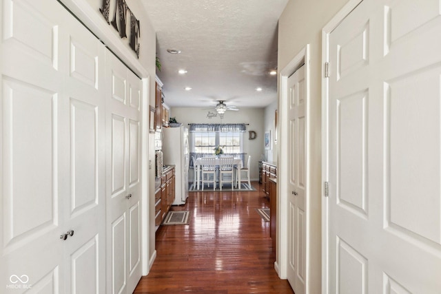 hall with dark hardwood / wood-style flooring and a textured ceiling