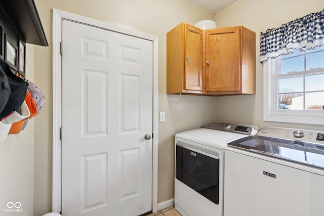 laundry area featuring cabinets, light tile patterned floors, and washing machine and dryer