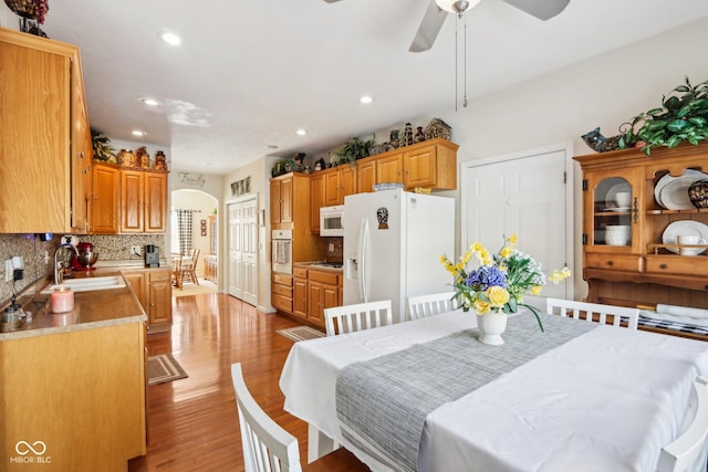 dining space featuring light wood-type flooring, ceiling fan, and sink