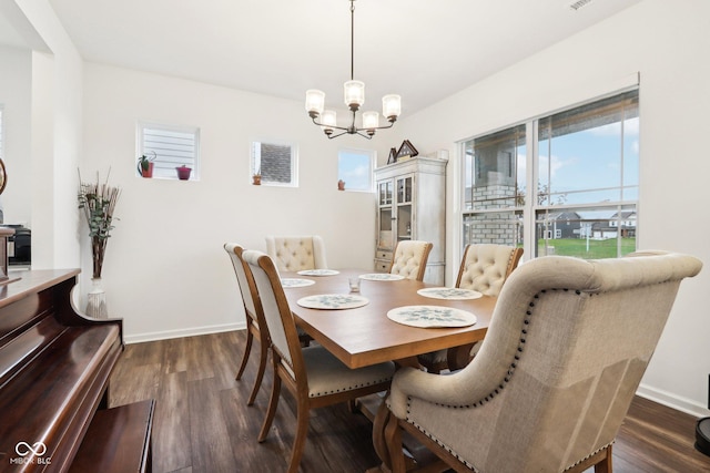 dining space featuring dark hardwood / wood-style floors and an inviting chandelier