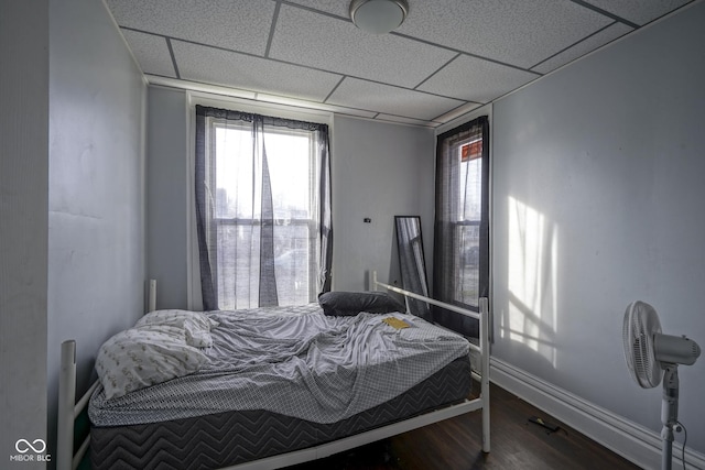 bedroom featuring hardwood / wood-style floors, a paneled ceiling, and multiple windows