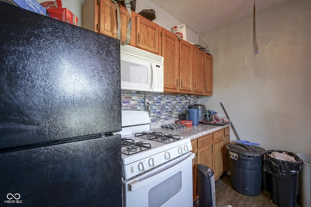 kitchen with dark hardwood / wood-style floors, white appliances, and tasteful backsplash