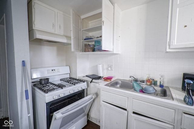 kitchen with backsplash, white range with gas cooktop, sink, and white cabinets