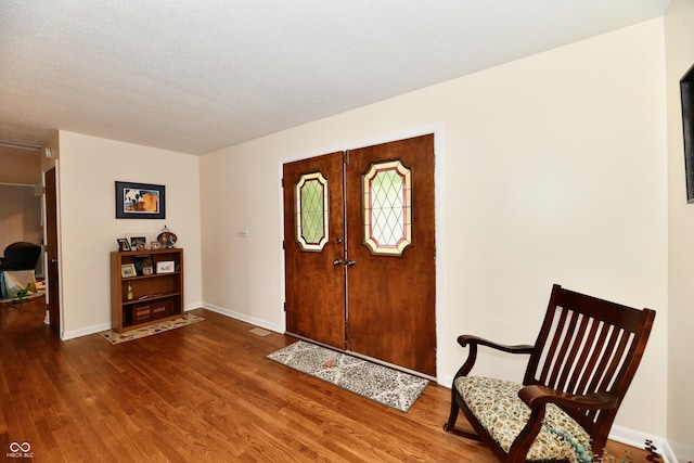 entryway with wood-type flooring and a textured ceiling