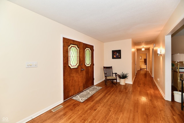 entryway with hardwood / wood-style floors and a textured ceiling