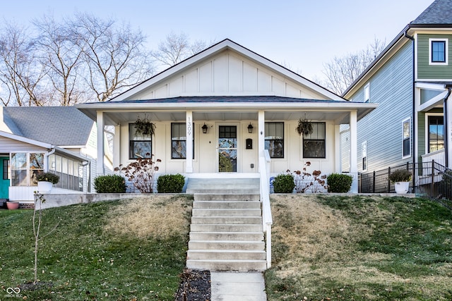 bungalow-style house featuring covered porch and a front lawn