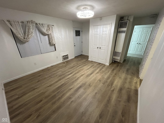 unfurnished bedroom featuring a closet and dark hardwood / wood-style flooring