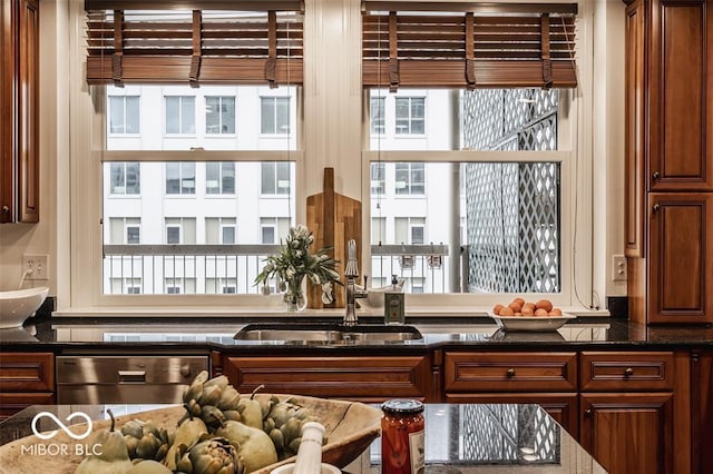 interior space featuring stainless steel dishwasher, dark stone counters, and sink