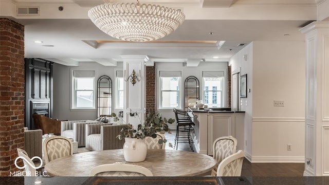 dining space with a healthy amount of sunlight, dark hardwood / wood-style floors, and an inviting chandelier