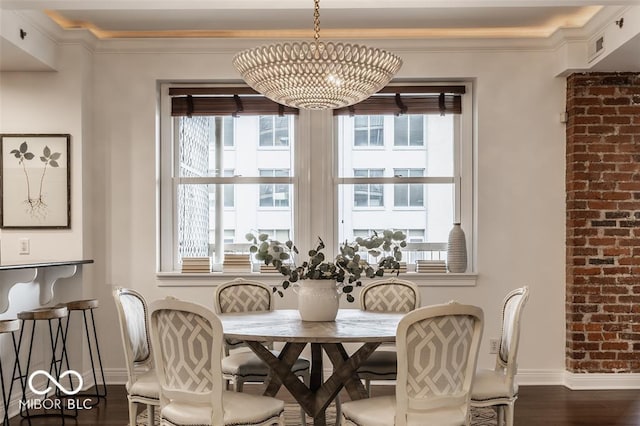 dining space featuring ornamental molding, dark wood-type flooring, and an inviting chandelier