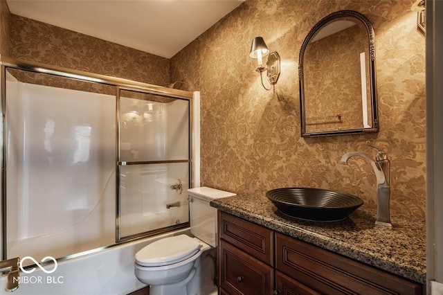 full bathroom with toilet, vanity, and combined bath / shower with glass door