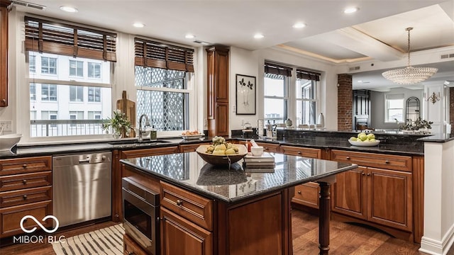 kitchen with appliances with stainless steel finishes, a center island, a wealth of natural light, and dark wood-type flooring