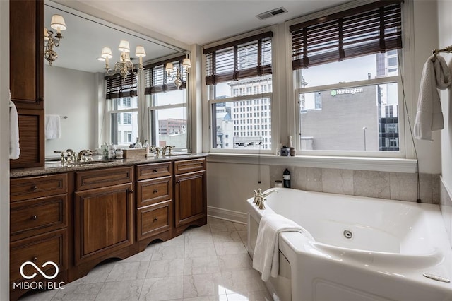 bathroom with vanity, a tub, and a notable chandelier