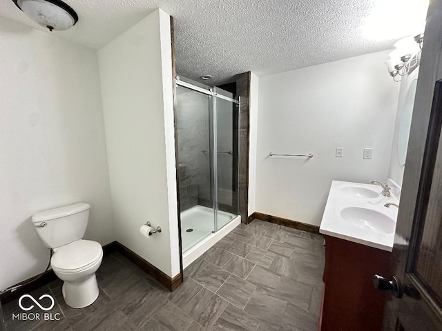 bathroom with toilet, an enclosed shower, a textured ceiling, and vanity