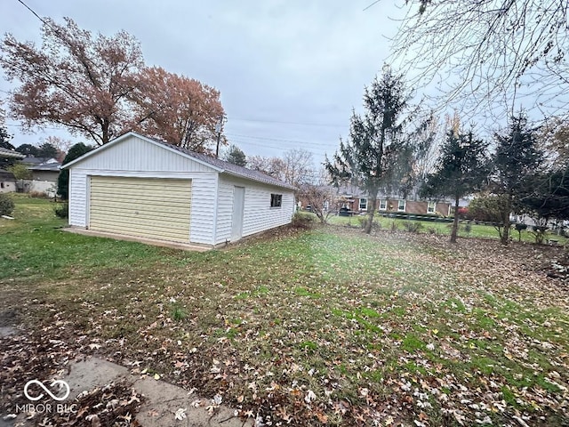 view of yard featuring a garage and an outbuilding