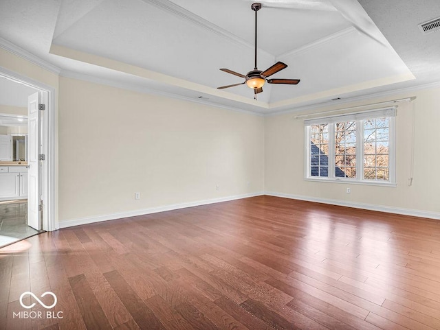 spare room with hardwood / wood-style floors, a raised ceiling, ceiling fan, and crown molding