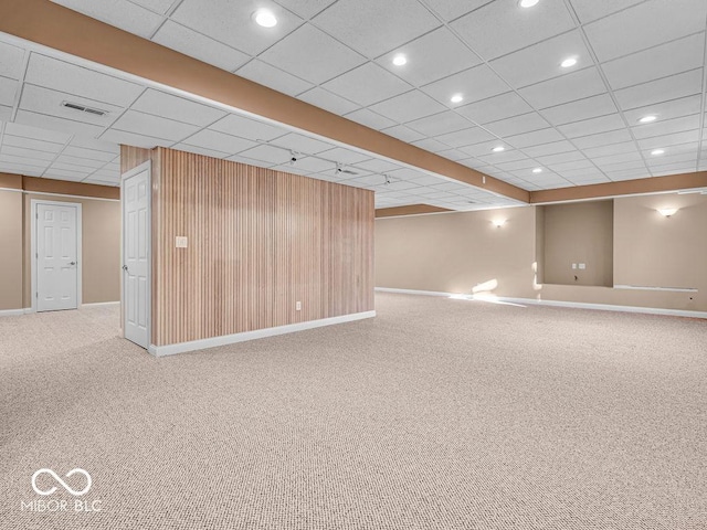 basement featuring a paneled ceiling and carpet floors