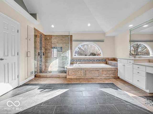 bathroom featuring separate shower and tub, vanity, and vaulted ceiling