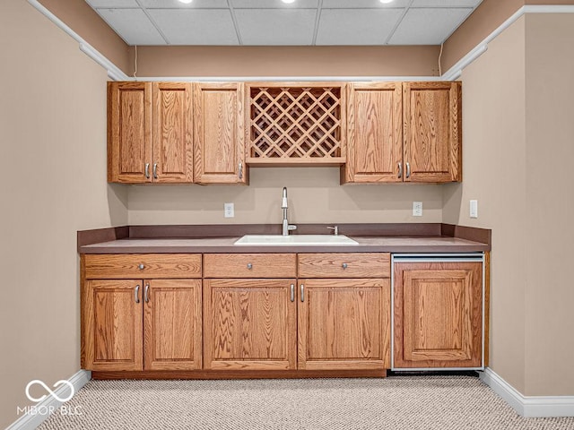 kitchen with a paneled ceiling, sink, and light carpet