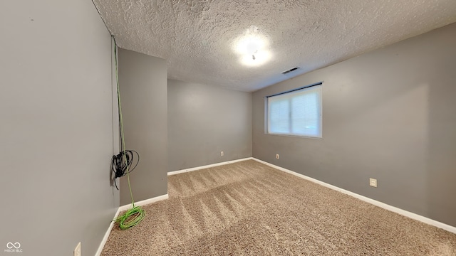 unfurnished room with carpet flooring and a textured ceiling