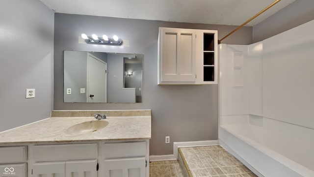 bathroom with washtub / shower combination, vanity, and tile patterned flooring