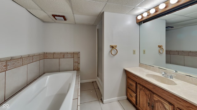 bathroom with vanity, a paneled ceiling, tile patterned floors, and a bathtub