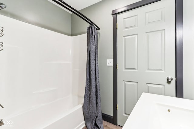 bathroom with hardwood / wood-style flooring and shower / tub combo with curtain