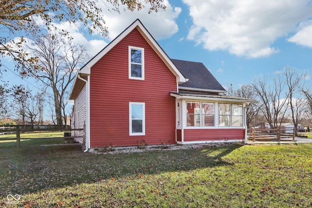 back of house with a lawn and a sunroom